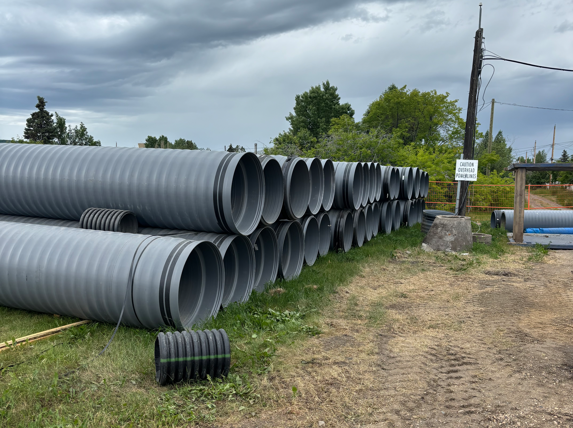 HP Storm Plastic Pipe Stacked in two rows within a construction site.